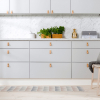 Kjøkken med slette fronter i en lys grå/blå farge med lys benkeplate med marmor-mønster