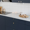 Kjøkken med lys benk med marmor-mønster og fronter i den mørke blåfargen storm