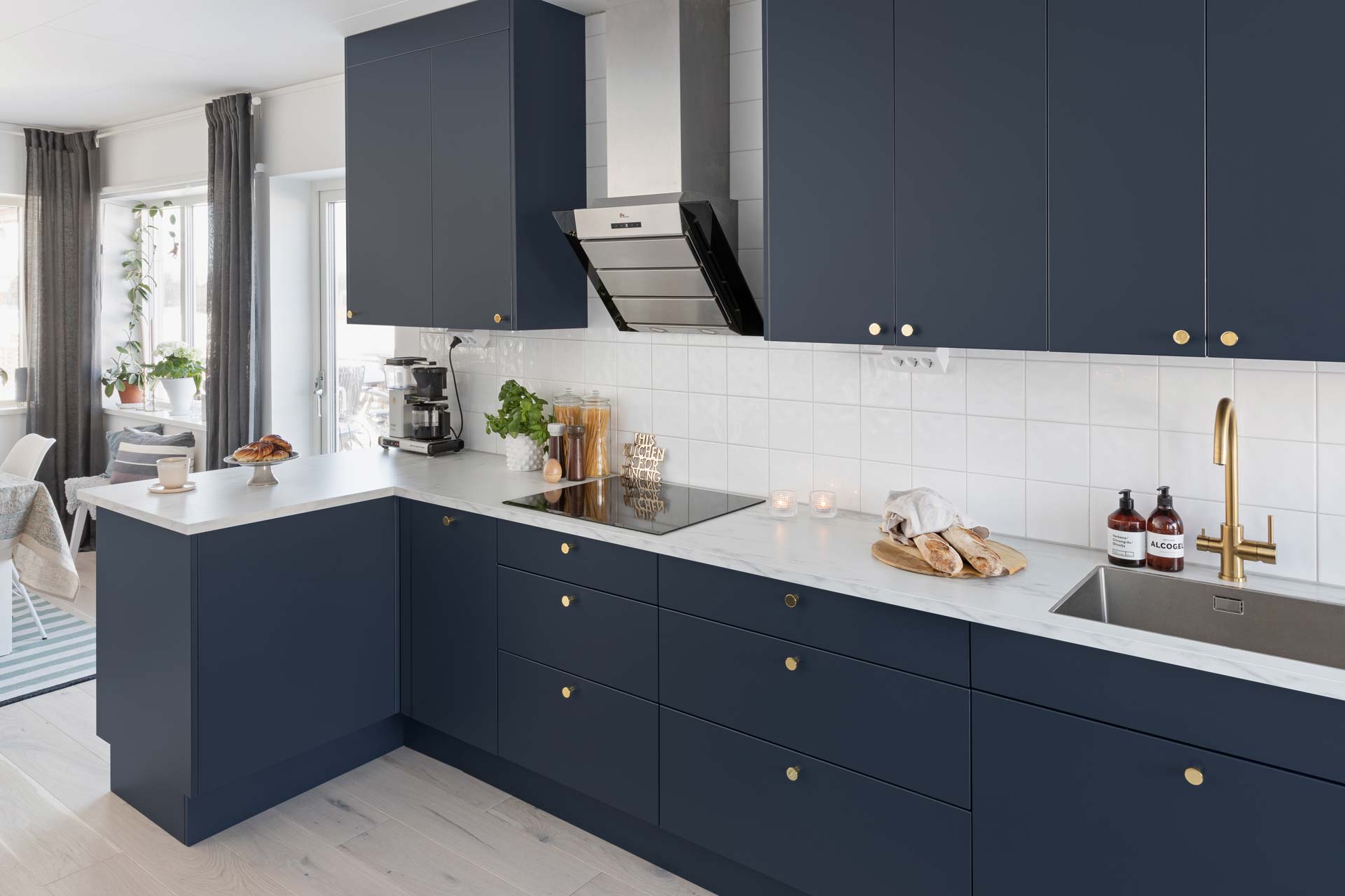Kjøkken med Slett R3 kjøkkenfronter i den mørke blå tonen Storm med Oas knotter i messing